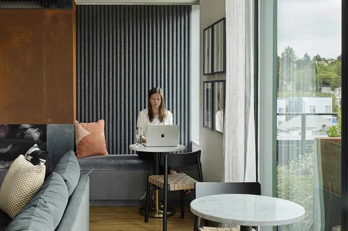 Modern apartment living room with cozy seating area, stylish decor, and large window offering scenic views.