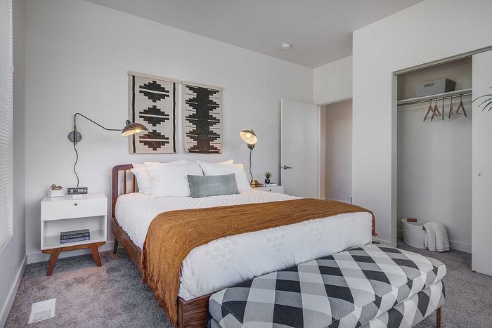 Chic bedroom with modern decor featuring cozy bed, stylish accent lighting, and spacious closet.