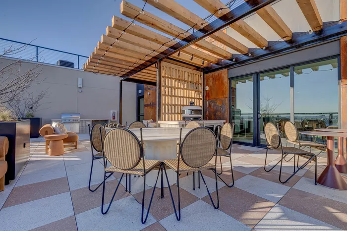 Chic rooftop patio with modern pergola, stylish seating, and a scenic view, perfect for dining and relaxation.