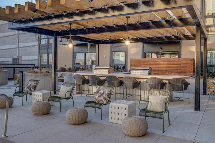 Chic outdoor patio with elegant seating, modern pergola, and ambient lighting, perfect for relaxing and entertaining.