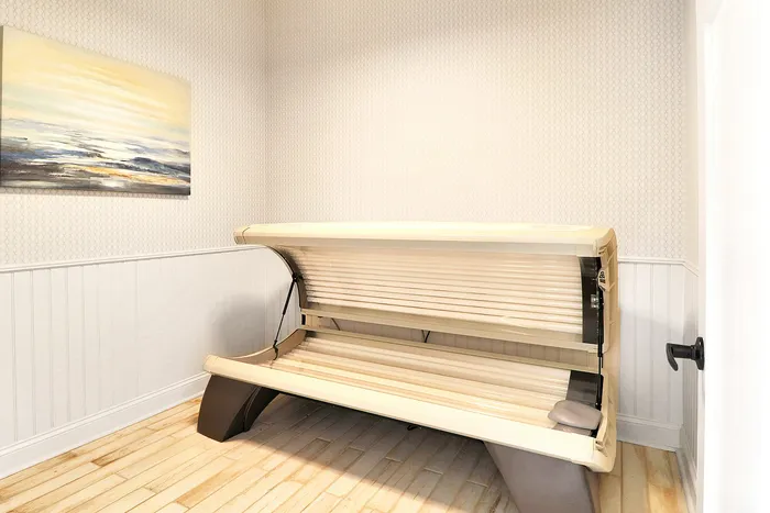 Bright room featuring a modern tanning bed against a stylishly textured wallpaper, complemented by tranquil landscape artwork.