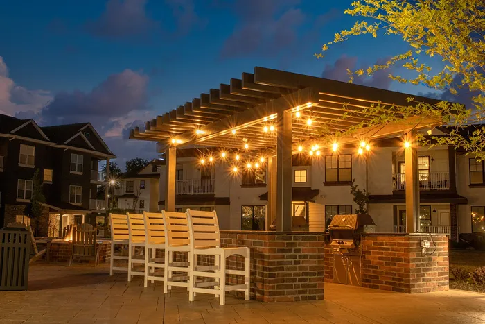 Charming outdoor patio with warm string lights, stylish pergola, and comfortable seating offering a perfect evening retreat.