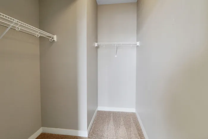 Spacious walk-in closet with sleek shelving and ample storage space, perfect for organized living.