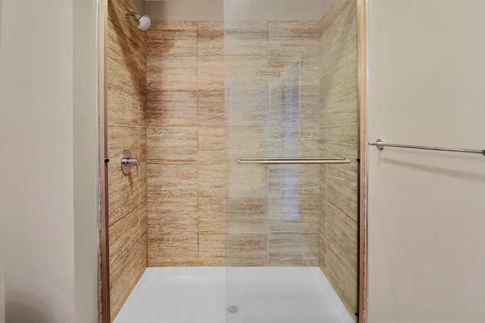 Elegant bathroom shower with modern tile design and sleek glass door, exuding luxury and sophistication.