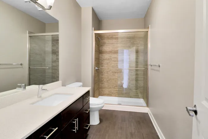 Elegant bathroom featuring a spacious glass-enclosed shower, sleek vanity with modern fixtures, and neutral-toned walls for a serene atmosphere.