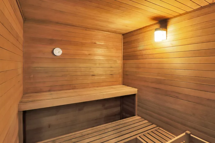 Inviting wooden sauna room with warm lighting and comfortable benches, perfect for relaxation and rejuvenation.