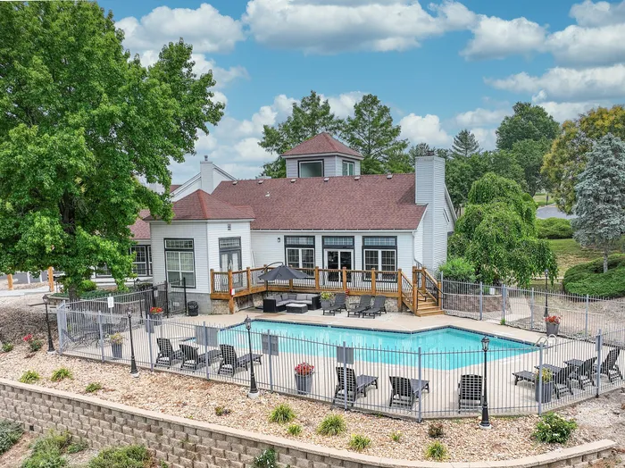 Charming residential retreat with a sparkling pool, spacious deck, and lush landscaping, perfect for relaxation and entertainment.