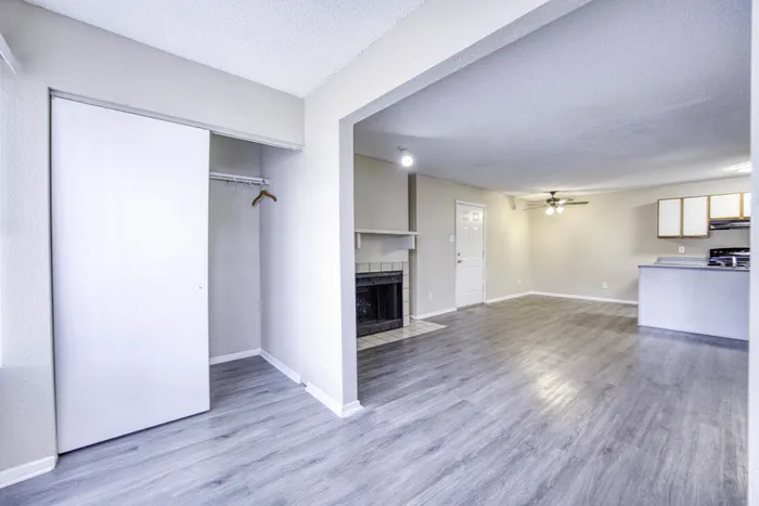 Bright open living space featuring modern flooring, a cozy fireplace, and a stylish kitchen area with sleek cabinetry.