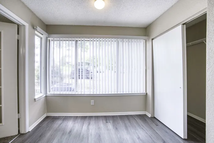 Bright and inviting room with large windows and sleek hardwood floors, perfect for natural light enthusiasts.
