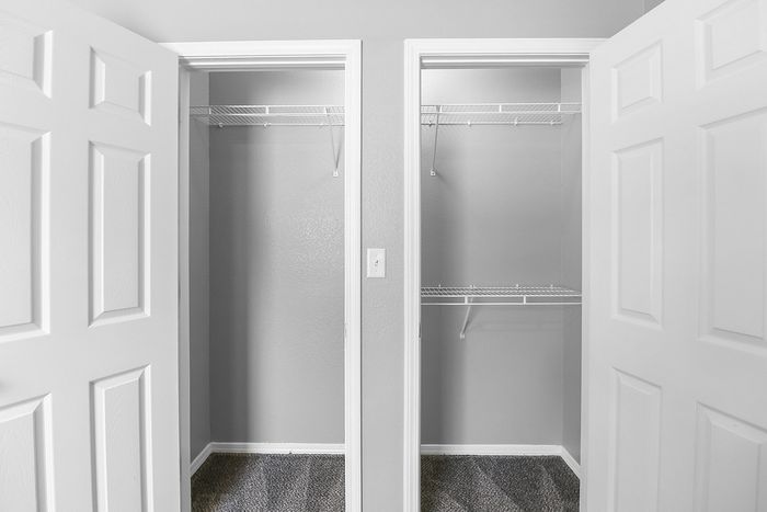 Spacious dual closets with white shelving, perfect for ample storage in a modern apartment.