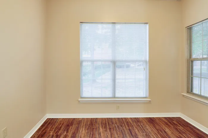 Bright and inviting room with large windows, elegant wooden floors, and a serene atmosphere, perfect for relaxation.
