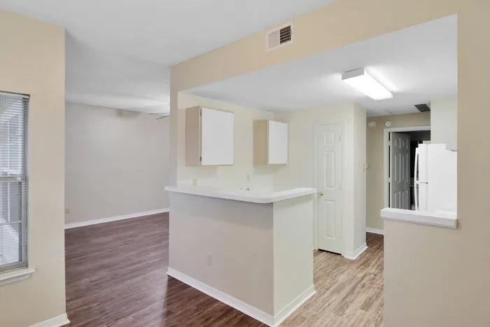 Bright and modern open-concept kitchen with sleek countertops, spacious cabinets, and elegant hardwood flooring.