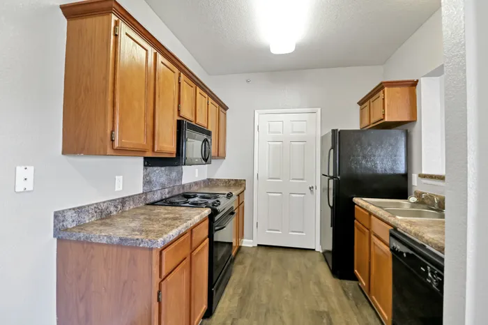 Inviting kitchen with modern appliances, warm wooden cabinetry, and sleek countertops promising both style and functionality.
