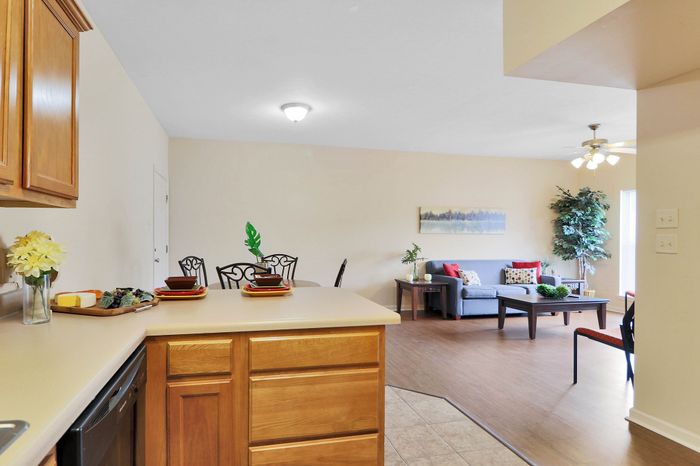 Bright and airy open-concept living space with modern kitchen and cozy seating area, accented with stylish decor.
