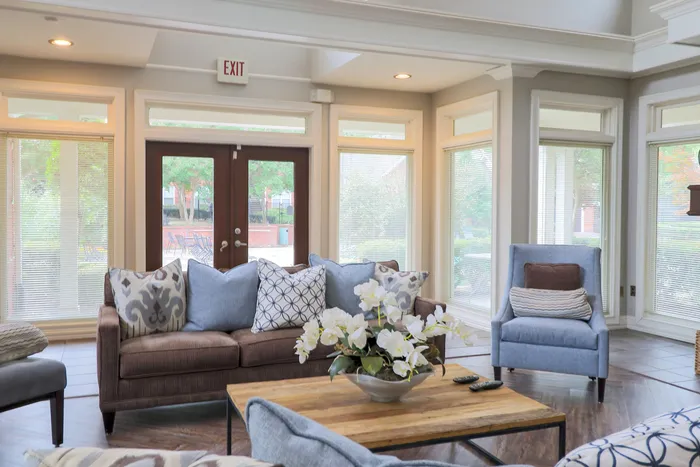 Bright and welcoming living room with plush seating, vibrant cushions, and large windows offering ample natural light.