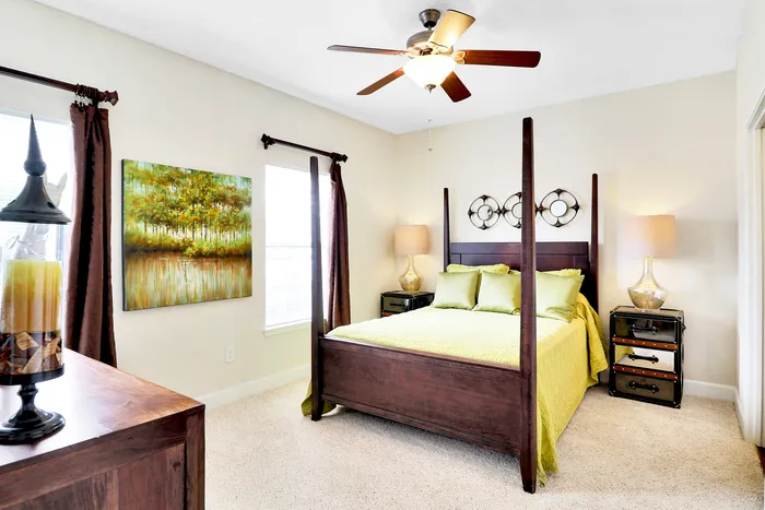 Inviting bedroom with elegant four-poster bed, modern decor, and cozy neutral tones, offering a serene retreat ambiance.