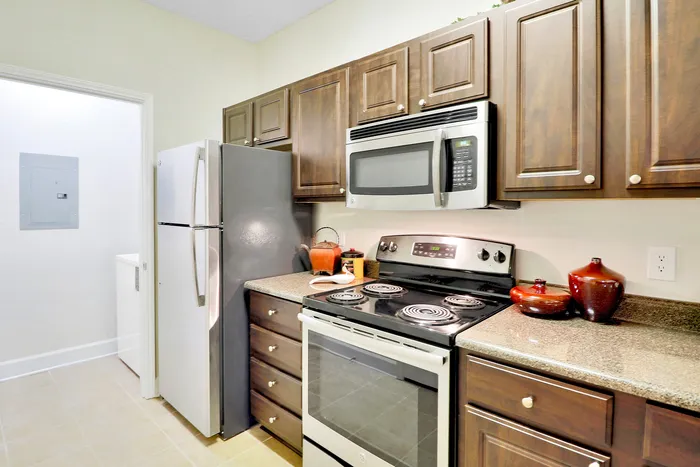 Modern kitchen with sleek stainless steel appliances, rich wooden cabinets, and elegant countertop decor.