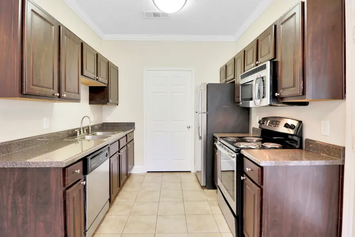 Modern kitchen with elegant dark cabinetry, stainless steel appliances, and sleek countertops offering a sophisticated cooking space.