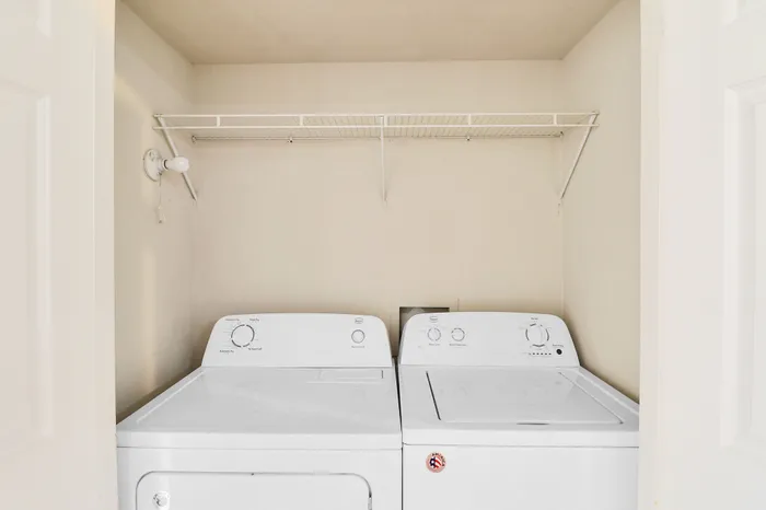 Modern laundry area with efficient washer and dryer, featuring ample shelving for convenient storage.