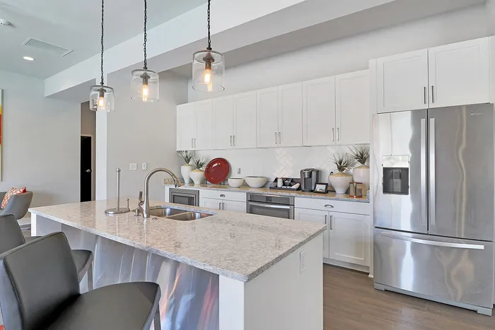 Chic modern kitchen with sleek stainless steel appliances, granite countertops, and stylish pendant lighting.