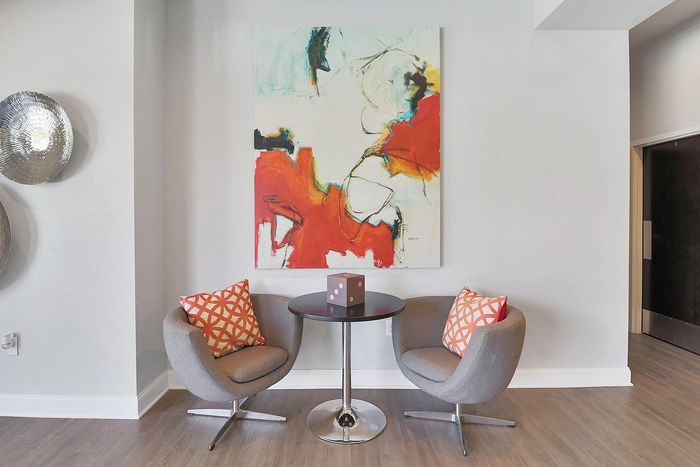 Chic modern seating area with abstract art and stylish decor, perfect for a cozy apartment setting.