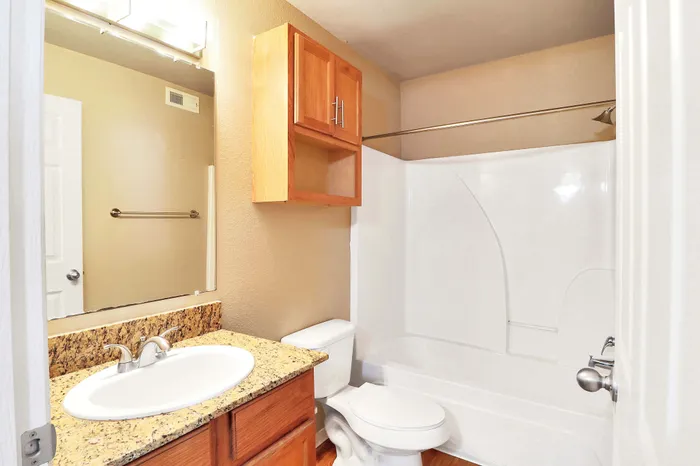Elegant bathroom with granite countertop, modern fixtures, and ample natural light.