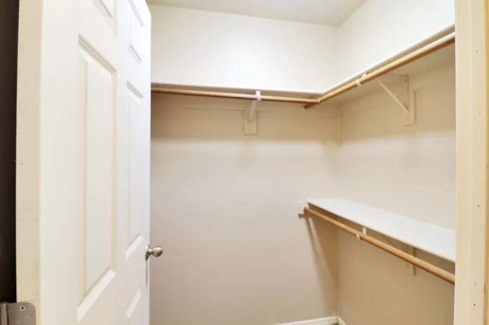 Spacious walk-in closet with ample shelving and hanging space, perfect for organized storage solutions.