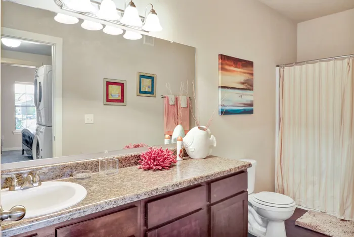 Bright and inviting bathroom featuring elegant granite countertops, a spacious vanity with modern lighting, and artful decor for a serene ambience.