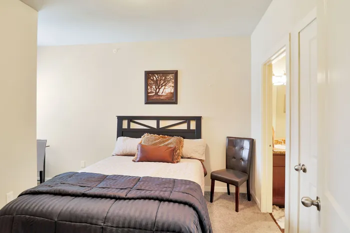 Inviting bedroom with plush bedding, modern artwork, and en-suite access for ultimate comfort.