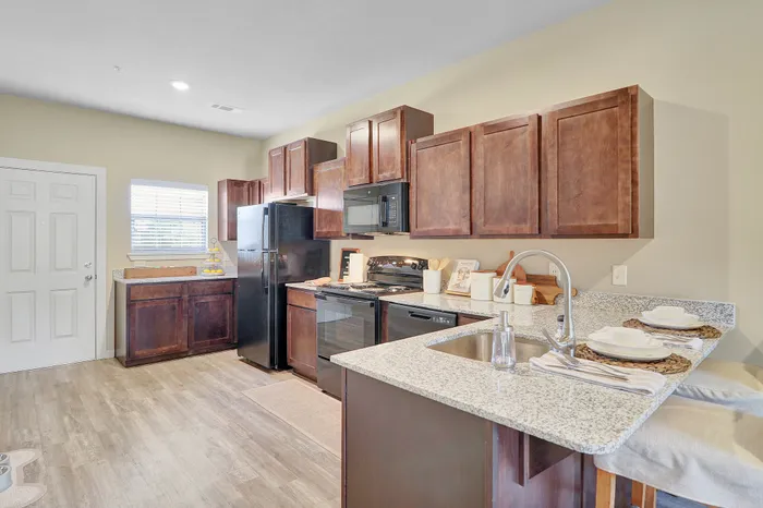 Modern kitchen with granite countertops, sleek appliances, and elegant wood cabinetry, offering a welcoming and functional space.