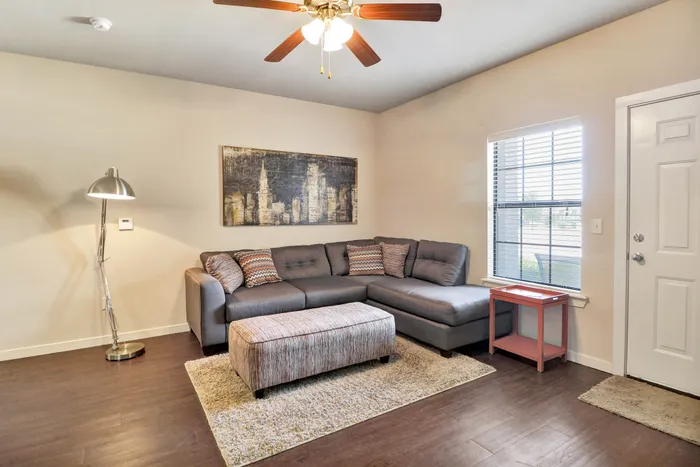 Inviting living room with a modern sectional sofa, stylish floor lamp, and chic wall art, showcasing a blend of comfort and elegance.