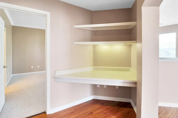Inviting nook with built-in shelves and desk area, perfect for a home office setup in the comfort of your apartment.
