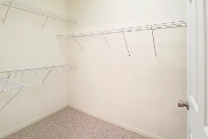 Spacious walk-in closet with built-in shelving and ample storage opportunities in a modern apartment.