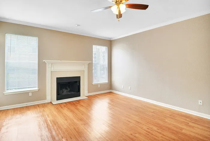 Bright and inviting living room with elegant fireplace, hardwood floors, and large windows for natural light.