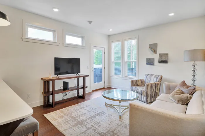 Bright and inviting living room featuring modern decor, cozy seating, large windows, and stylish lighting for a welcoming atmosphere.