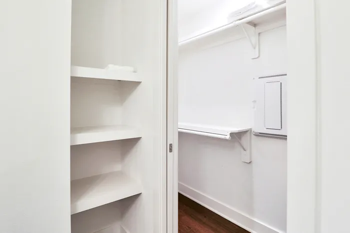 Sleek and modern walk-in closet featuring built-in shelving and ample storage space, perfect for organizing your wardrobe.