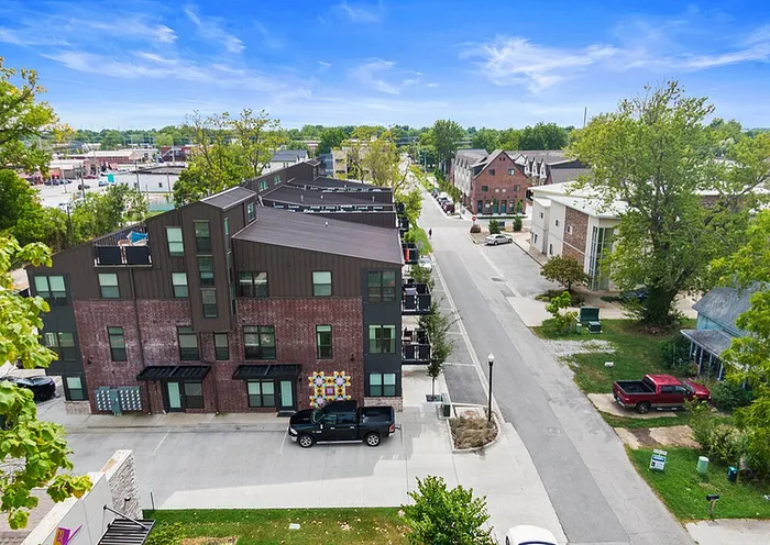 Charming urban townhouse complex with modern brick design on a tree-lined street with vibrant neighborhood views.