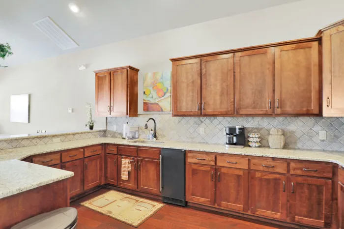 Elegant kitchen with warm wood cabinetry, modern appliances, and spacious granite countertops, perfect for culinary creativity.