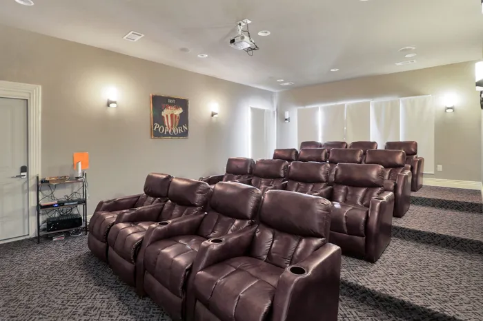 Luxurious private theater room with plush leather recliners and cozy lighting, perfect for an immersive movie experience at home.