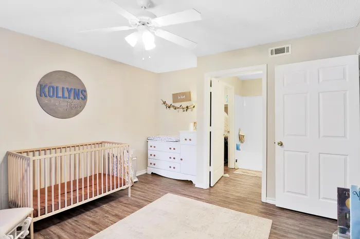 Cozy nursery room with a wooden crib, changing table, and charming decor, perfect for a growing family.