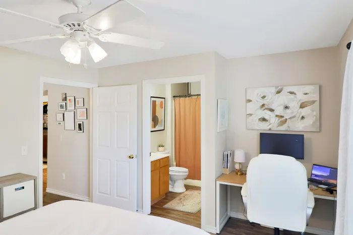 Bright bedroom with home office nook, elegant decor, and private bathroom access.