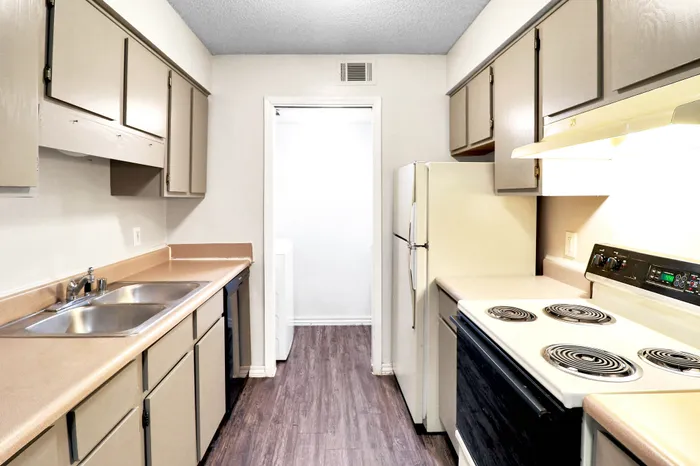 Charming galley kitchen with sleek countertops, abundant cabinetry, and modern appliances, perfect for culinary creativity.