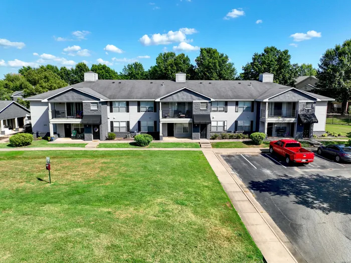 Charming apartment building with spacious balconies, lush green lawns, and ample parking in a serene neighborhood.