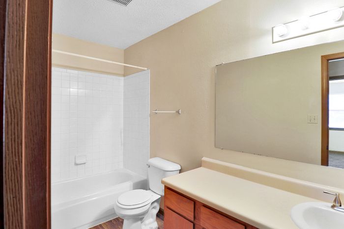 Bright and inviting bathroom with clean white tiles, modern sink, and ample mirror space perfect for a fresh start to your day.