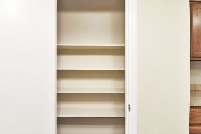 Spacious built-in closet with multiple shelves, perfect for organizing essentials in a modern apartment.
