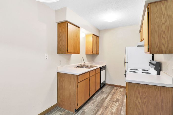 Charming kitchen with sleek countertops, warm wooden cabinetry, and modern appliances, perfect for culinary delights.