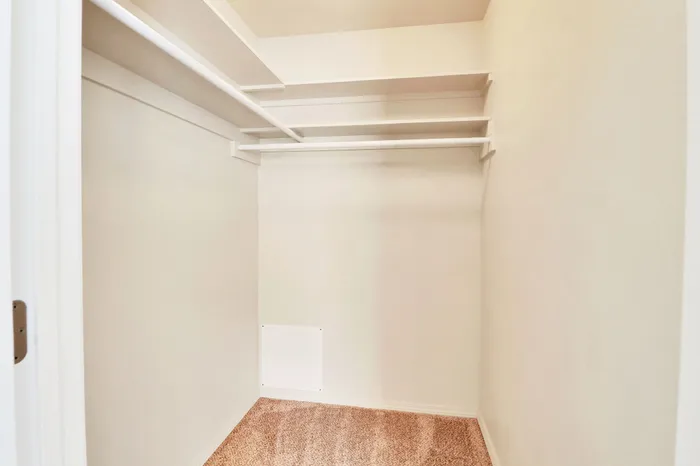 Spacious walk-in closet with built-in shelving and ample room for storage.