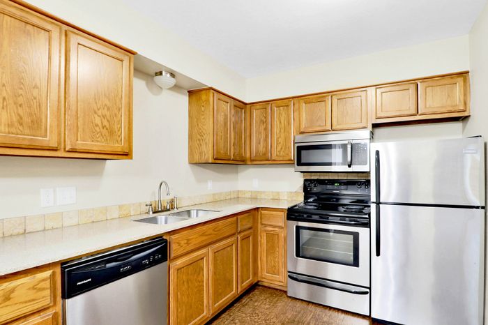Modern kitchen with stainless steel appliances, sleek wooden cabinets, and a stylish tile backsplash.
