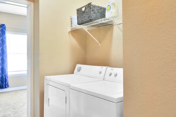 Bright and efficient laundry space featuring modern washer and dryer in a cozy apartment setting.