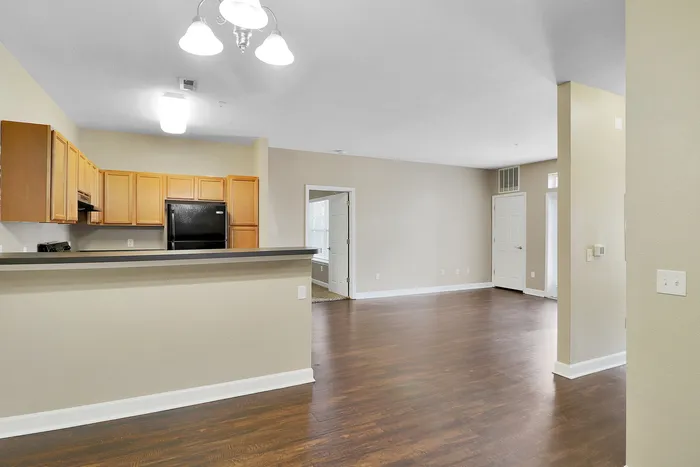 Inviting open-concept living space with modern kitchen, elegant hardwood floors, and ample natural light.